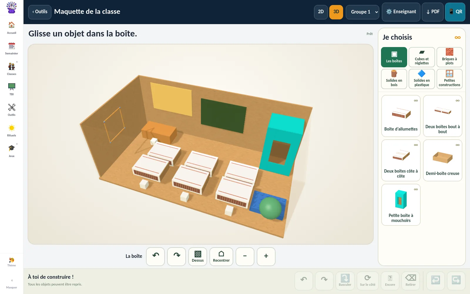Un modèle de classe de l’application : bancs, tableau et mobilier dans une maquette en carton.